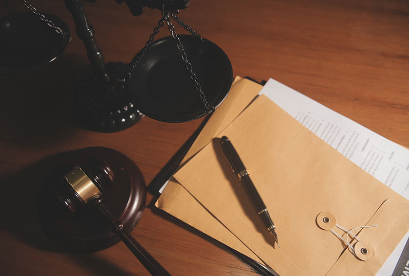 Attorneys analyzing legal documents next to a brass scale, illustrating record extracts, briefing rules, and transcript deadlines in Maryland appeals.